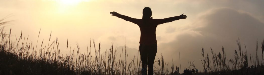 silhouette-woman-standing-field-against-sky-sunset